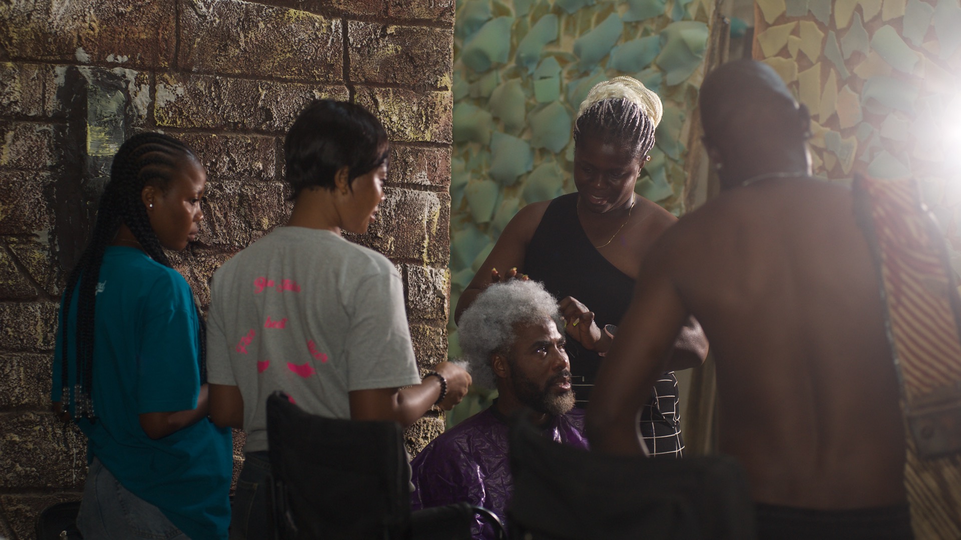 Udu Alakpa on What It Really Takes to Do Makeup on Film Sets 5 Udu Alakpa sets Ibrahim Chatta's hair on the set of 'Colours of Fire' © Anthill Studios - Nollywire